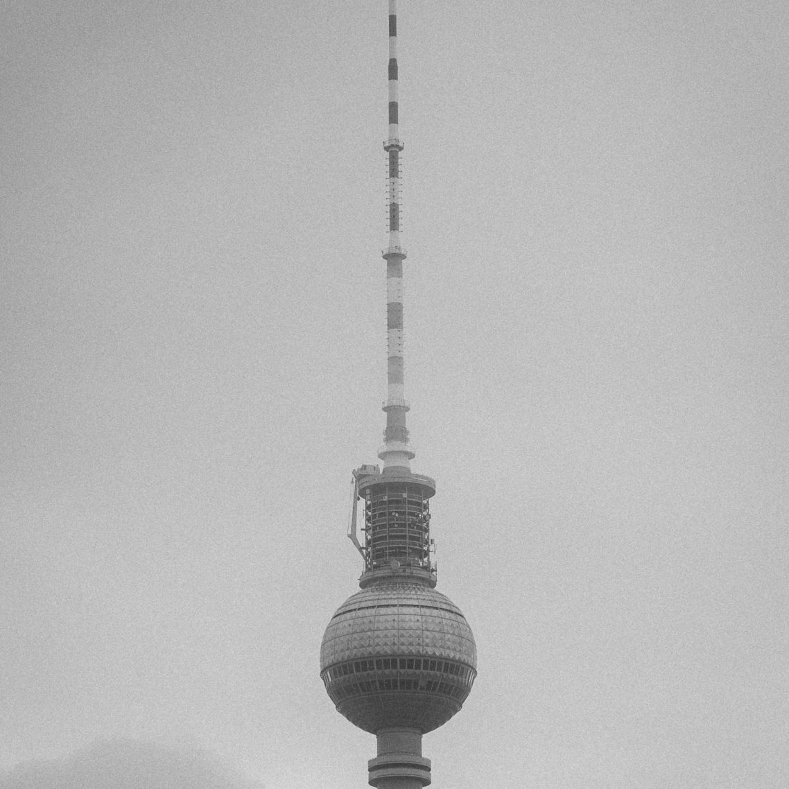 Fernsehturm Berlin in Schwarz-Weiß, mit charakteristischem Kugelbau und Antenne.